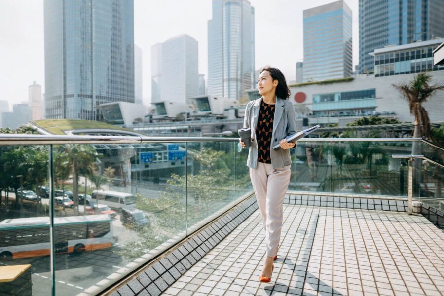 woman in business attire walking on building patio