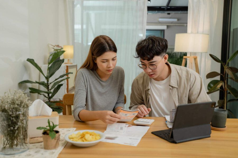 A young couple look at documents together at home.