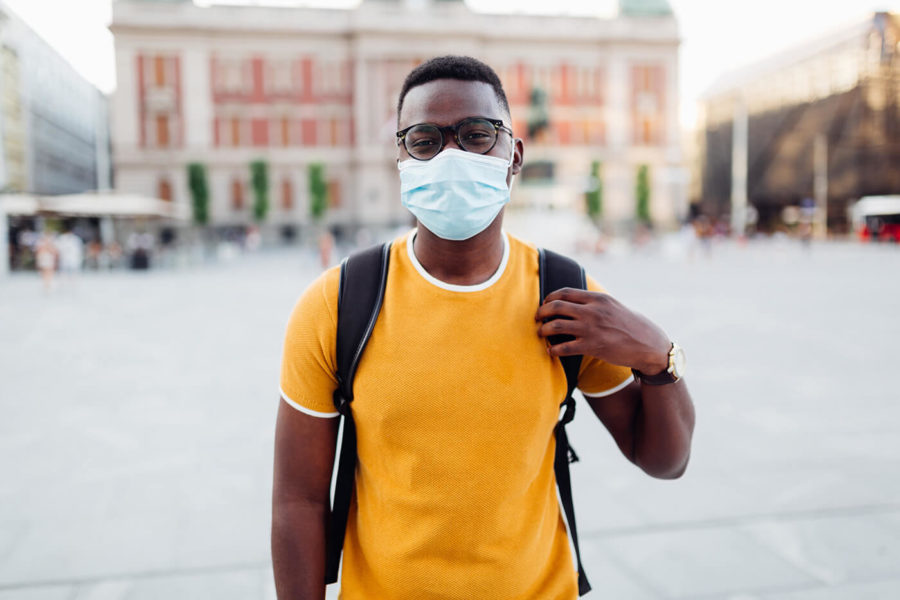 Portrait of a handsome young African American male student wearing a protective face mask