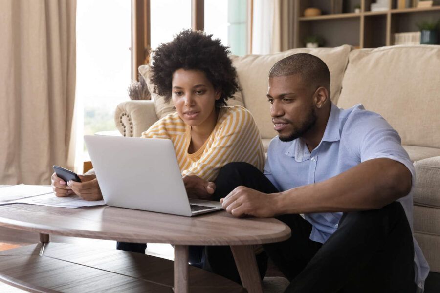 Concentrated young african american married couple looking at computer screen.
