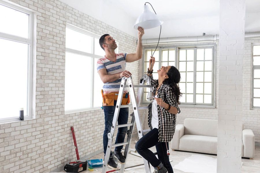 Couple making renovations, changing lighting equipment 