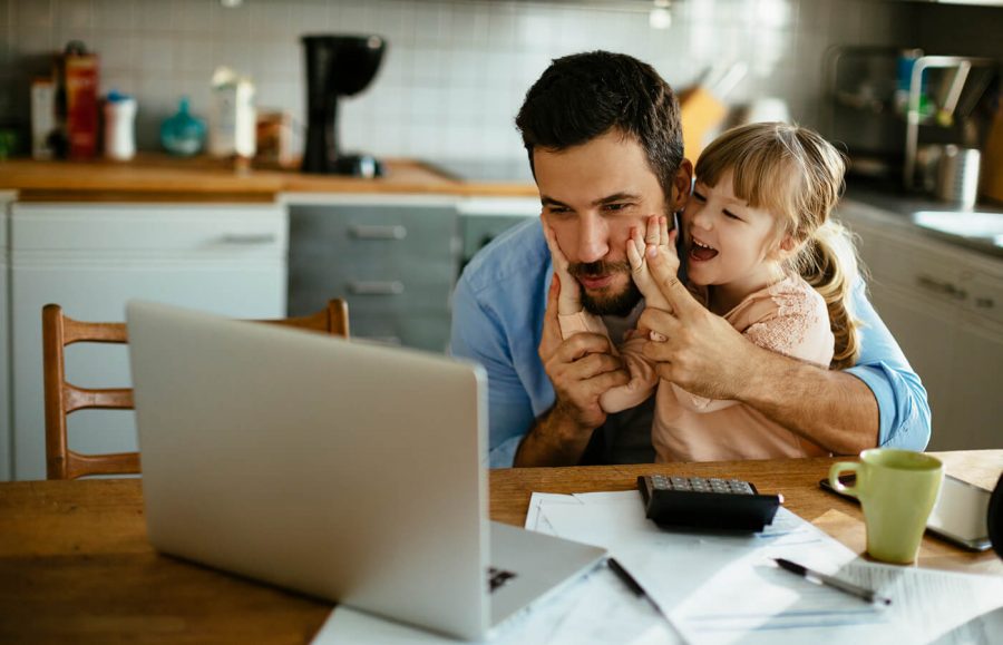 man sitting on table with young daughter looking at life insurance for child