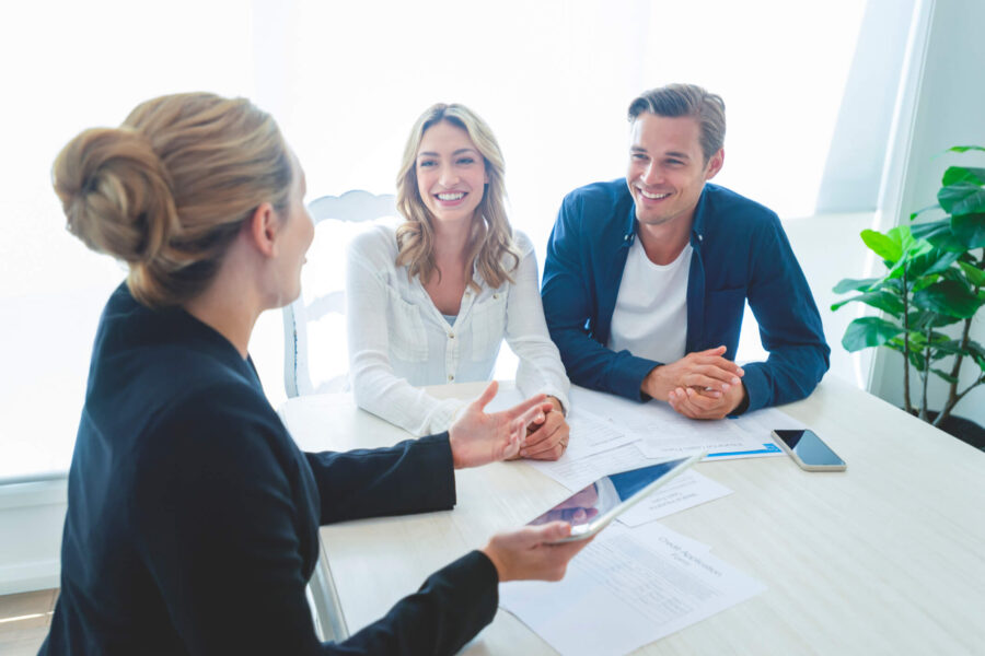 female financial advisor in consultation with man and woman couple