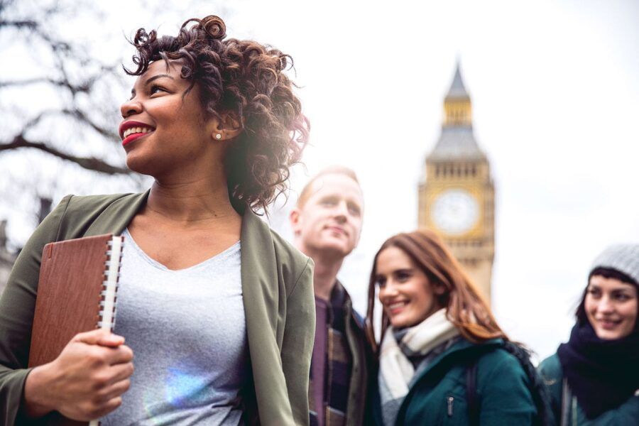A group of people smile outside while the Big Ben clocktower is in the background.