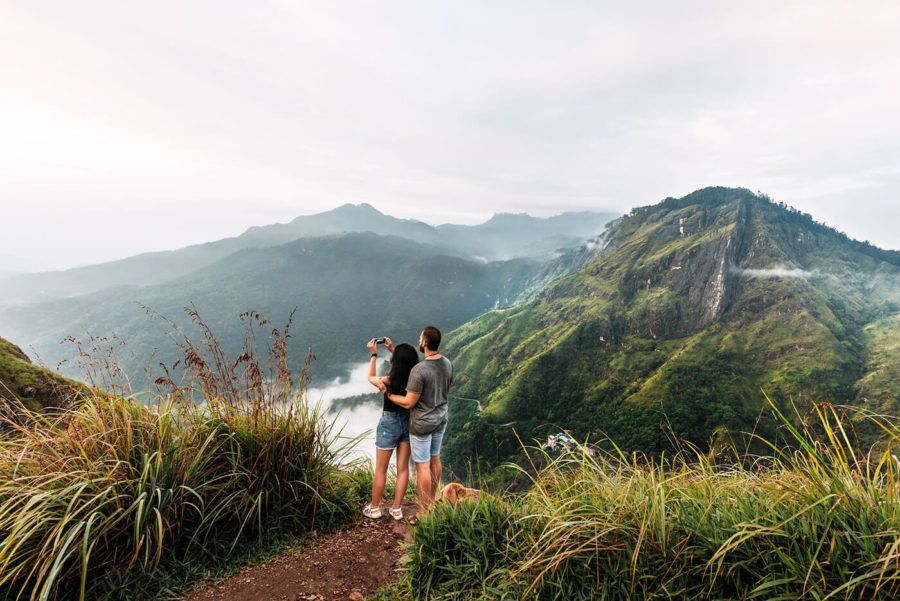 The couple travels the world. A couple in love travels to Sri Lanka. The couple travels to Asia. Man and woman meet the dawn in the mountains. Vacation in Asia. Happy couple in the mountains. 