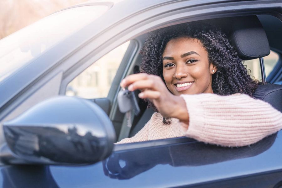 Young black woman at the wheel on her new car
