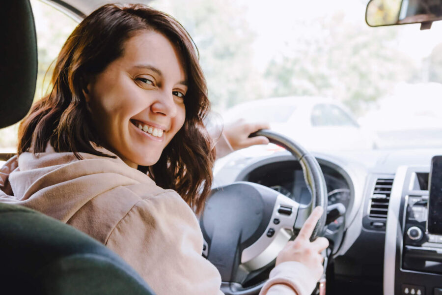 woman smiling while sitting in a car