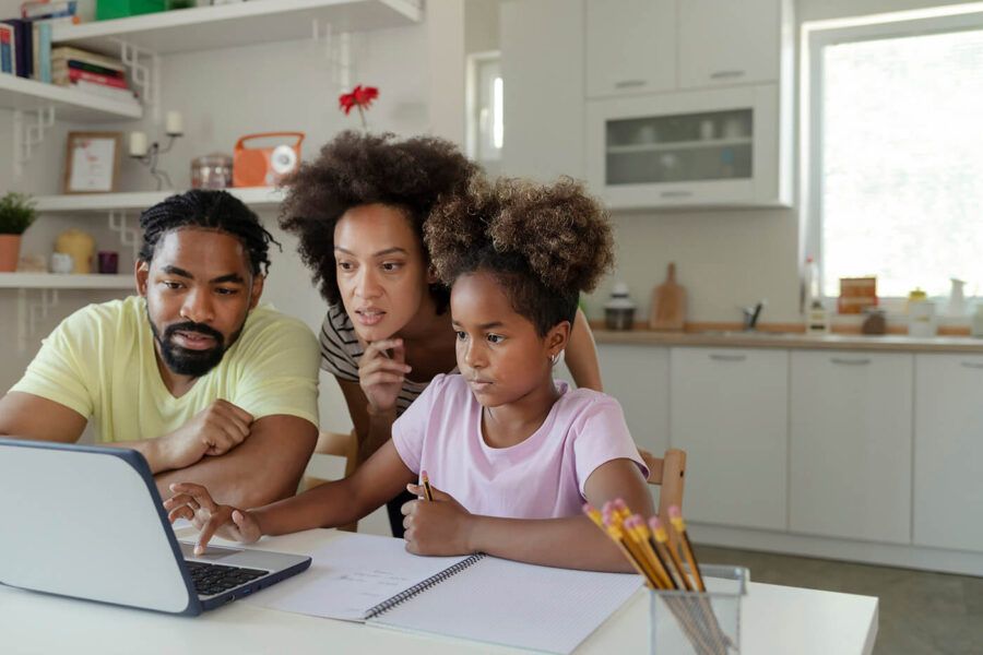 African American Parents Helping Their Daughter With Homework