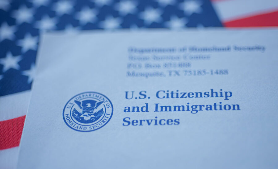 A U.S. Citizenship and Immigration Services document is on top of an American flag.