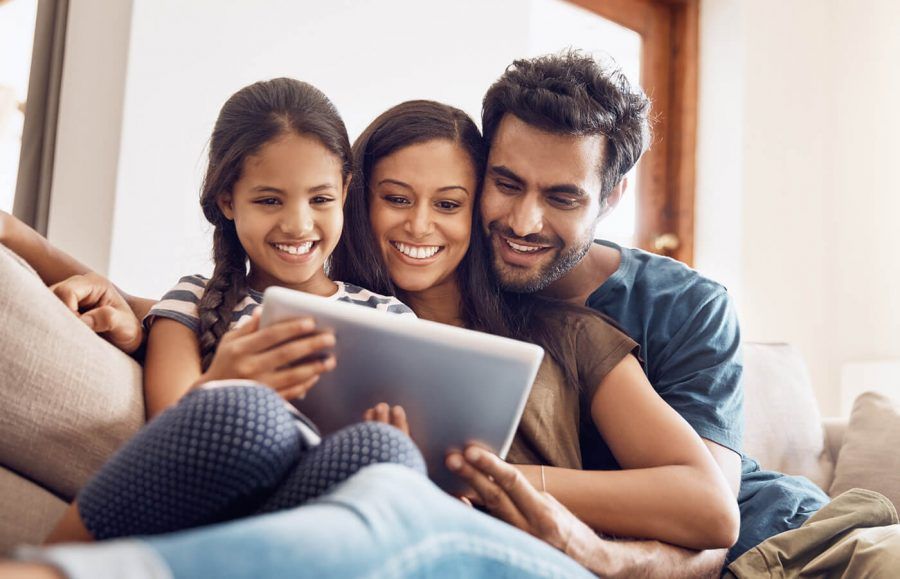 family of three looking at a tablet gamifying debt payoff to make it fun