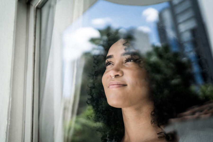 woman thinking whether to invest while looking outside window
