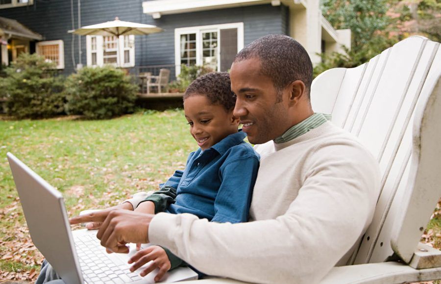 man sitting with kid while opening a brokerage account for child