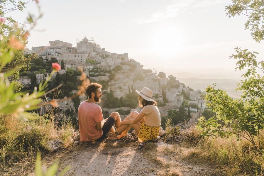 Young woman and man looking at scenic view of Gordes village in Provence
