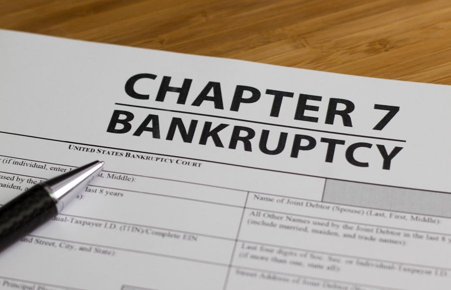 A form titled Chapter 7 Bankruptcy with a pen resting on it.