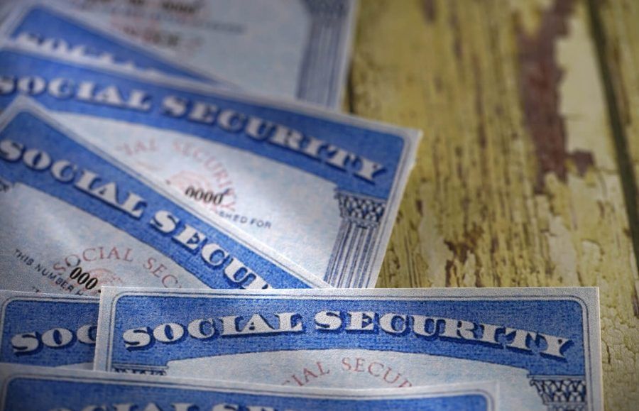 A pile of Social Security cards sitting at a desk in the sun.