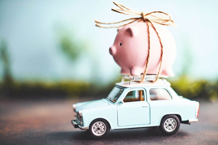 toy piggy bank tied on top of a toy car saving depiction