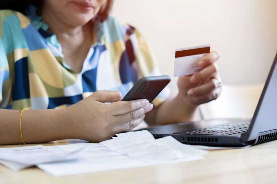 A woman holding smartphone and credit card.