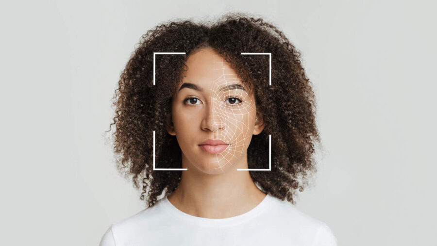 A woman with curly hair is getting her left face measured by biometrics.