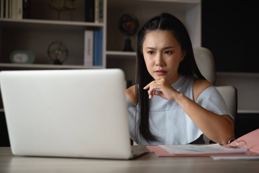 Concerned young woman using her laptop