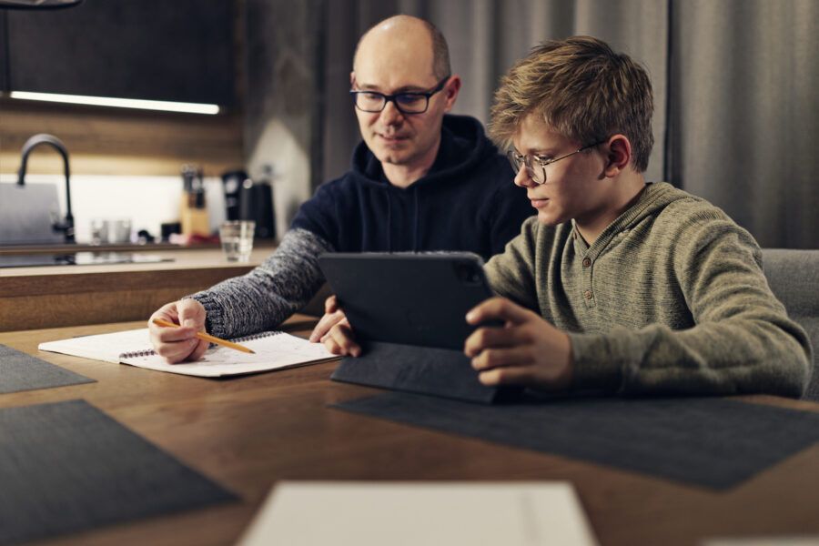Father and teenage son doing some paperwork together.