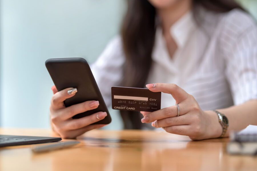 Close up. woman hands holding smartphone and using credit card for online shopping.