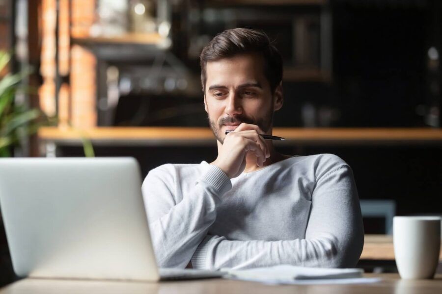 Pensive young man looking at the laptop screen