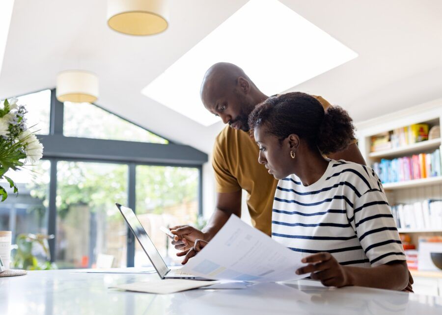 A couple paying taxes online at home using a laptop computer.