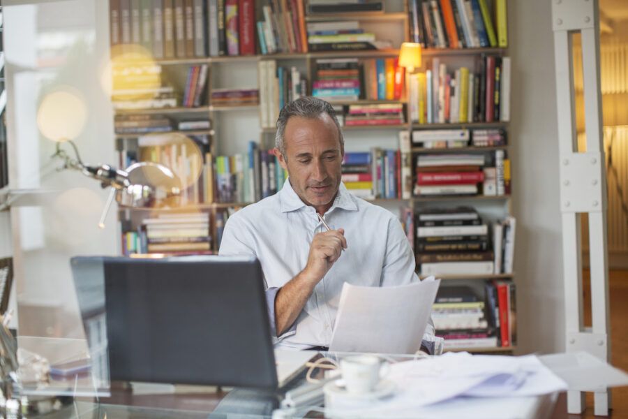 A man looking at his CD using a laptop