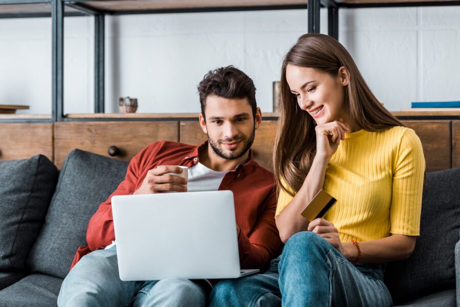 Couple sitting on the couch and applying for a credit card
