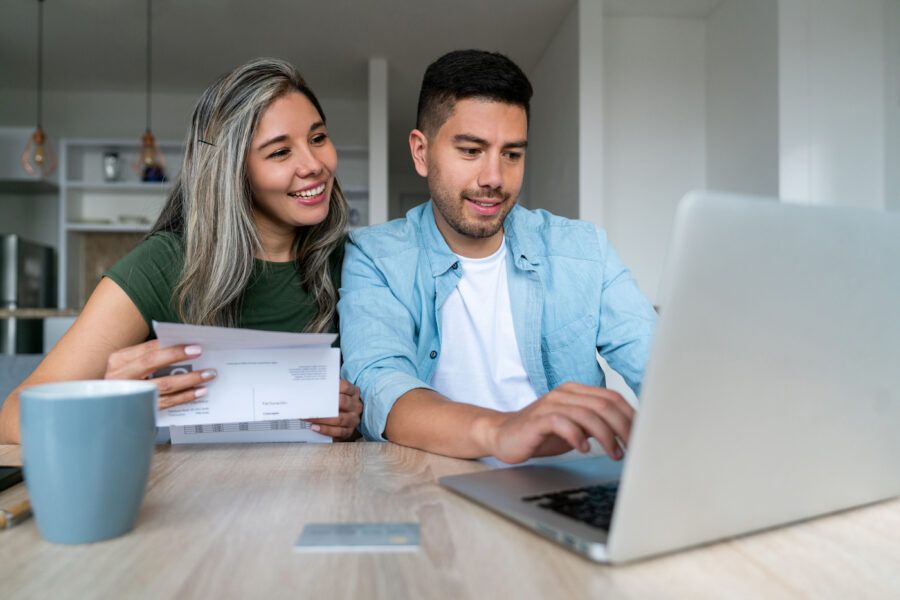 Happy couple at home budgeting online