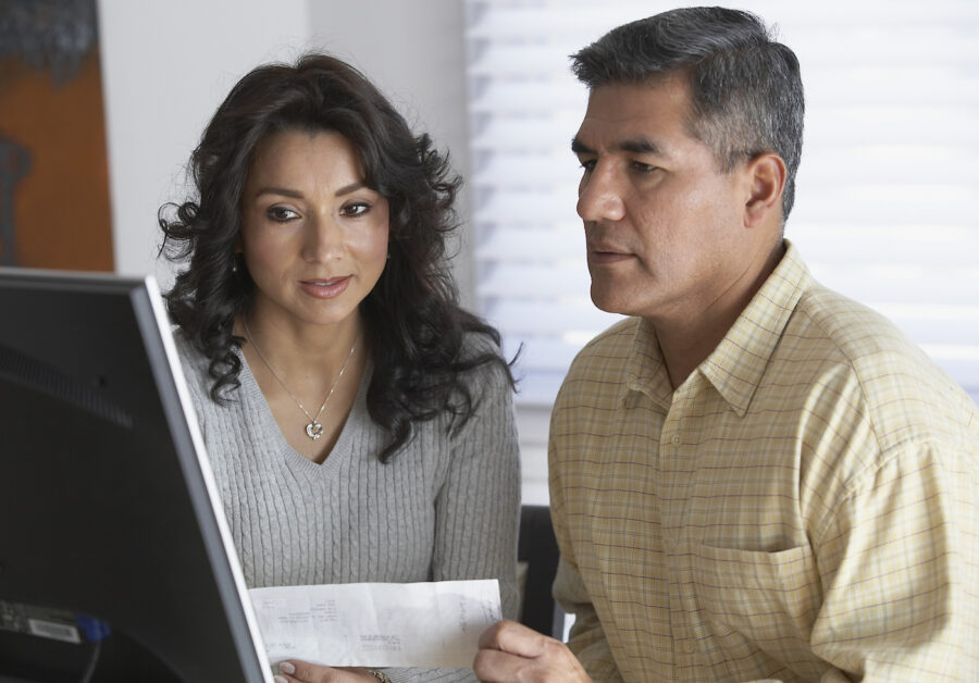 A couple looking at computer to learn about high-yield savings accounts and certificates of deposit.