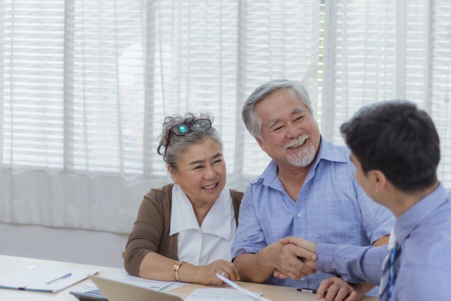 Happy retired eldery couple hands shaking deal and agreement with personal financial advisor