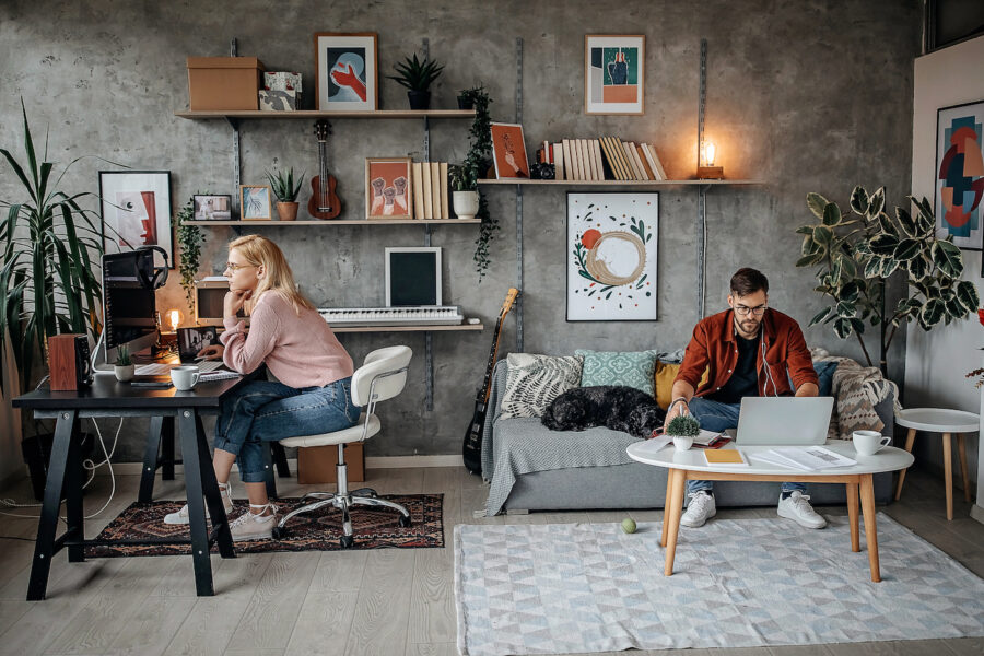 Young couple separately working on their finances at home