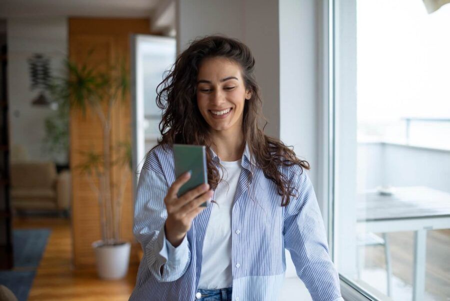 Smiling young woman checking her credit score in mobile app