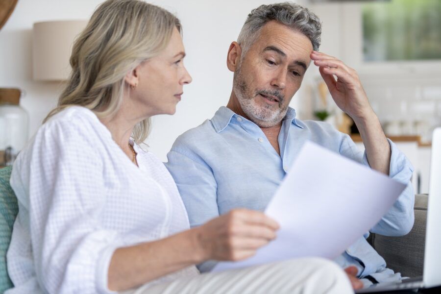 Mature woman shows some paperwork to her partner who seems concerned