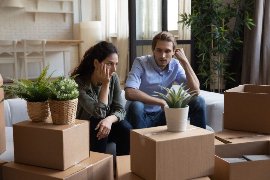 Divorced couple packing boxes, figuring out how to split mortgage
