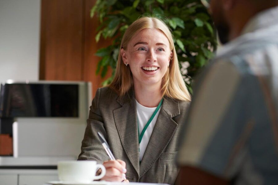 Smiling female financial planner talks to a customer in her office
