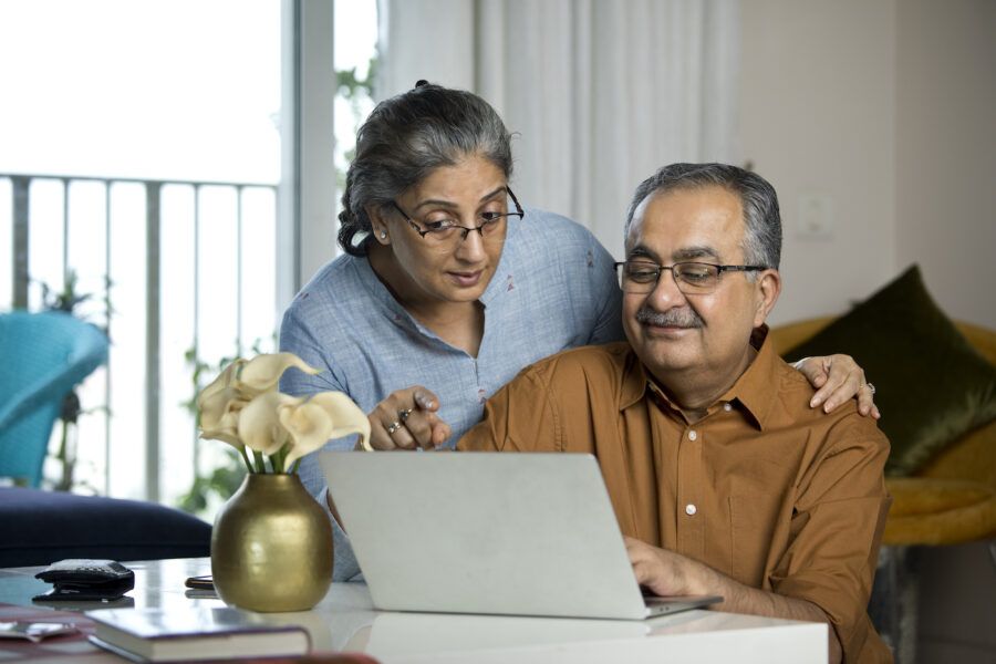 Elderly couple planning retirement on laptop