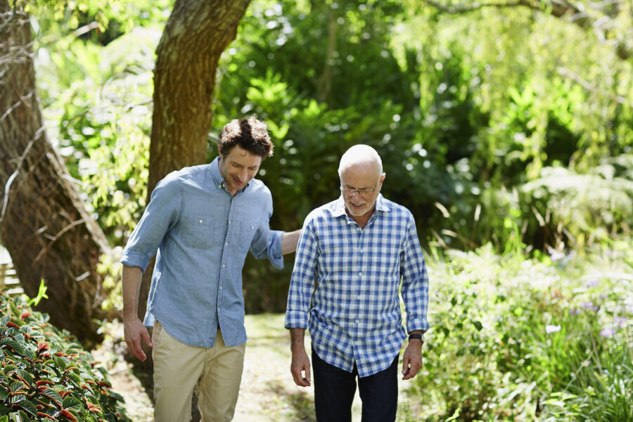 Happy senior man and son walking together in park