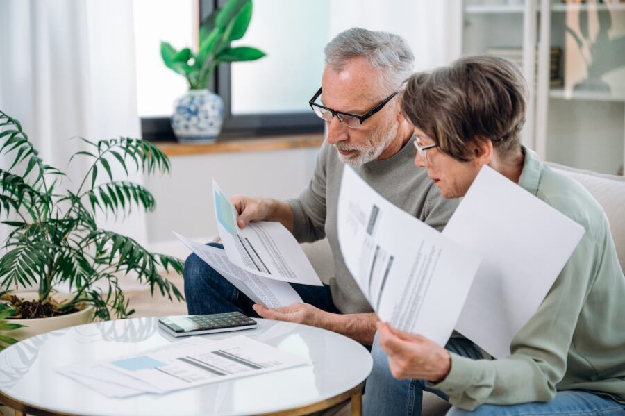 Mature couple checking documents for life insurance.