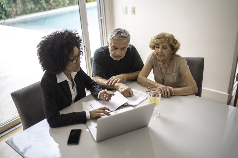 Financial advisor helping a senior couple pay off their mortgage at home