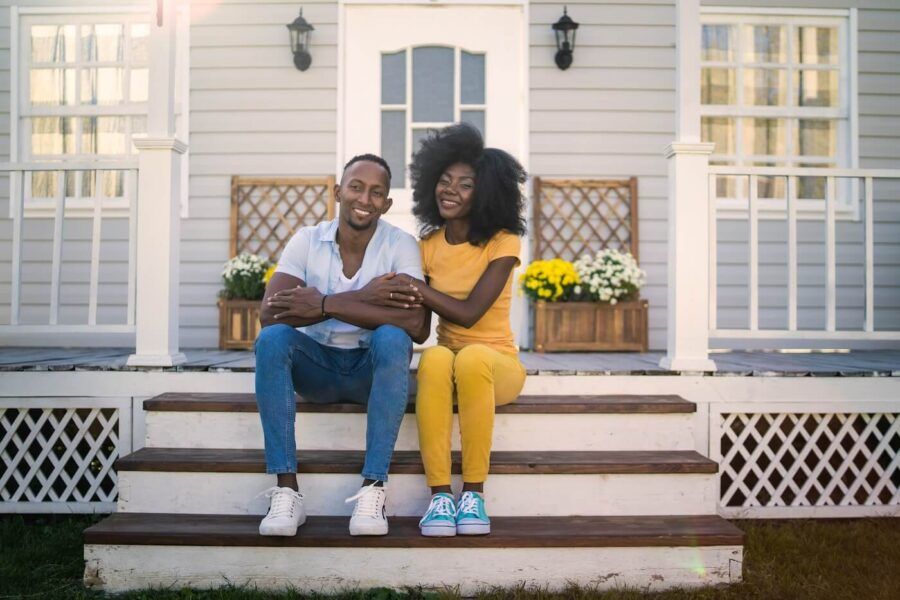 Happy young couple sitting on the porch of their first house