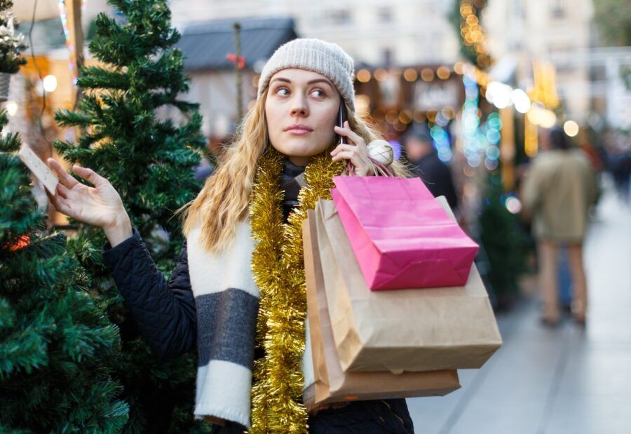 Portrait of girl shopping for holiday gifts and taking a phone call.