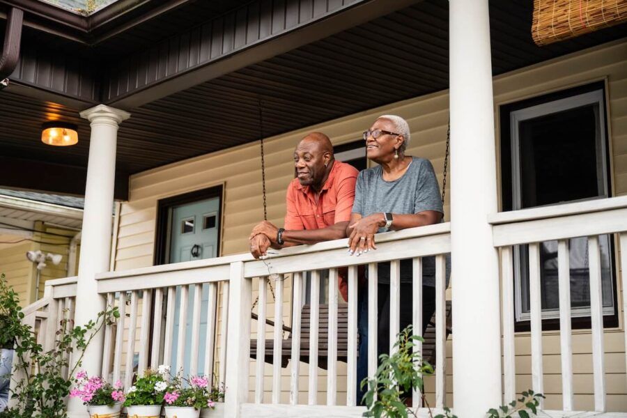 Smiling senior couple relaxing together on their front porch in the afternoon