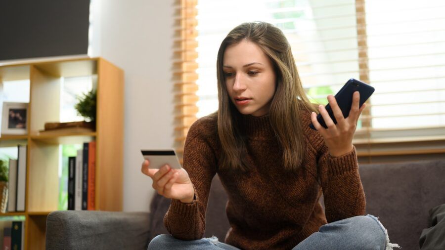 A young woman using smartphone to call her credit card company.