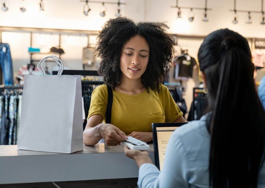 Young woman paying with a credit card at a department store checkout counter