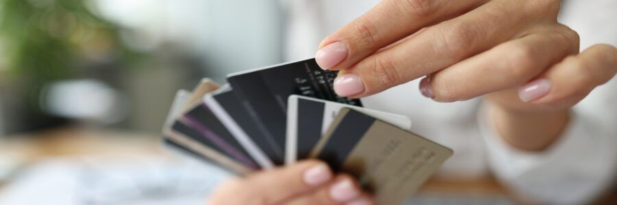Fan of plastic credit cards held in a woman's hand.