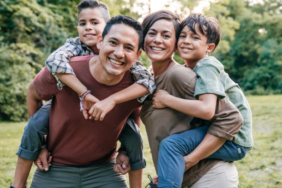 Happy family of four posing for a photo in the park