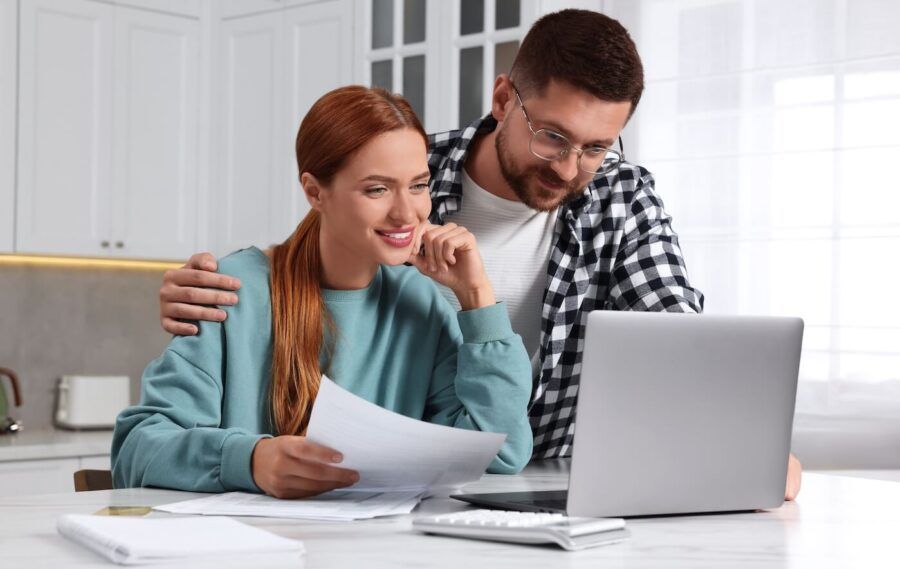 Happy couple using a laptop to plan their finances