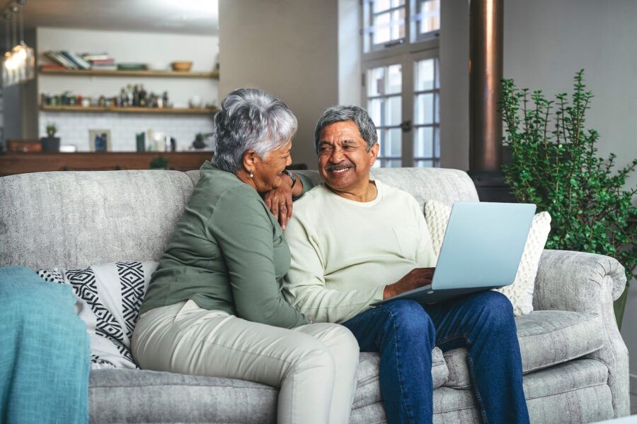 A retired couple looking into getting a mortgage. They are sitting together on a laptop.